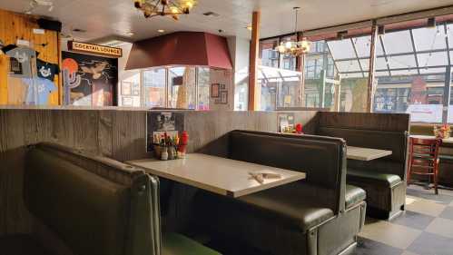 Interior of a diner with empty booths, a cocktail lounge sign, and large windows letting in natural light.