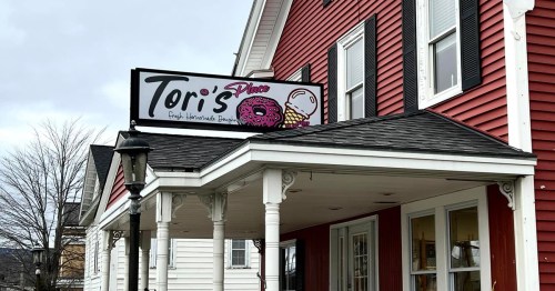 Sign for "Tori's Place" featuring fresh handmade donuts and ice cream, located on a red building with white trim.