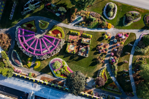 Aerial view of a beautifully landscaped garden featuring colorful flower beds and intricate designs.