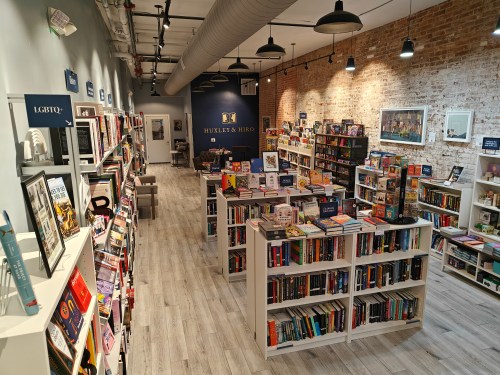 A cozy bookstore with wooden shelves filled with books, warm lighting, and a welcoming atmosphere.