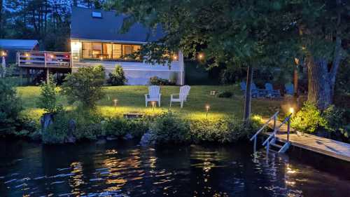 A serene lakeside scene at dusk, featuring a cozy house, chairs, and a wooden dock reflecting on the water.