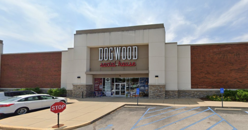 Exterior of Dogwood Social House, a casual dining venue, featuring a large sign and a parking area with a stop sign.