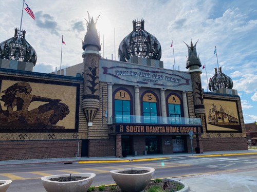 A large, ornate building with domed towers and murals, featuring "USA" and "South Dakota Home Grown" signage.