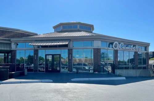 A modern restaurant with large windows and a circular roof, featuring a sign that reads "O'Clamers."