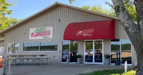 Exterior of a restaurant building with a red awning, featuring signs for "B-B-Q Grill" and "Burgers Grill."