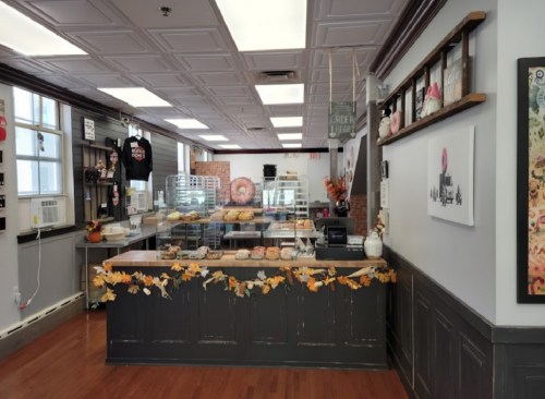 A cozy bakery interior featuring a display case of pastries, autumn decorations, and a warm, inviting atmosphere.