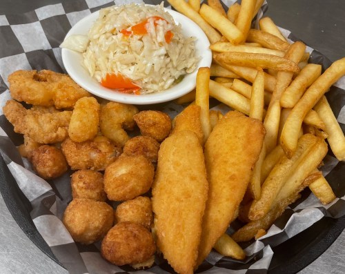 A platter featuring fried fish fillets, shrimp, hushpuppies, fries, and a side of coleslaw in a white bowl.