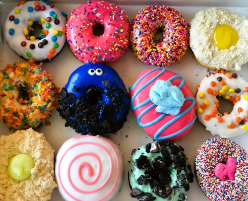 A colorful assortment of donuts with various toppings, including sprinkles, frosting, and unique designs.