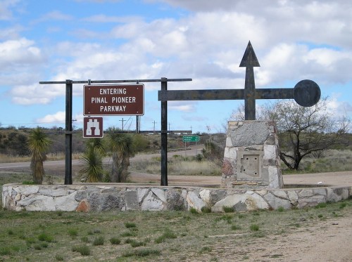 Sign marking the entrance to Pinal Pioneer Parkway, featuring a stone base and directional arrow.