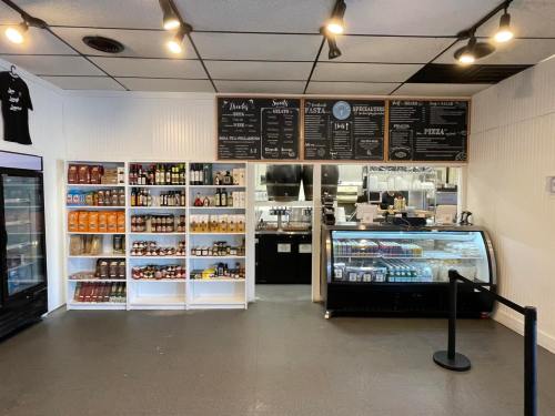Interior of a restaurant featuring shelves of products, a display case, and a menu board on the wall.