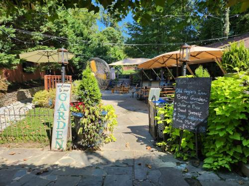 A sunny outdoor garden area with tables, umbrellas, and a sign welcoming visitors to a beer garden.