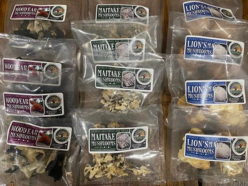 A variety of packaged dried mushrooms, including maitake, wood ear, and lion's mane, displayed in clear bags.