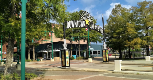 Sign reading "Downtown Lafayette" with trees and buildings in the background on a sunny day.