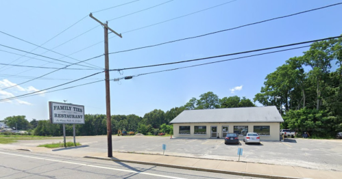 A restaurant named "Family Ties" with a parking lot, surrounded by trees and a clear blue sky.