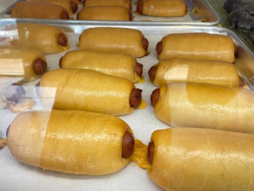 A display of several corn dogs on a tray, showcasing their golden-brown batter and hot dog filling.