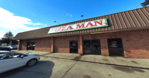 Exterior of a pizza restaurant named "Pizza Man," featuring a brick facade and a clear blue sky.