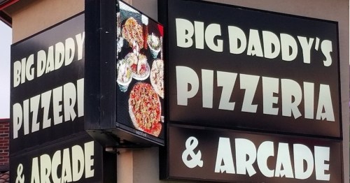 Sign for "Big Daddy's Pizzeria & Arcade" featuring colorful pizza images and bold text.