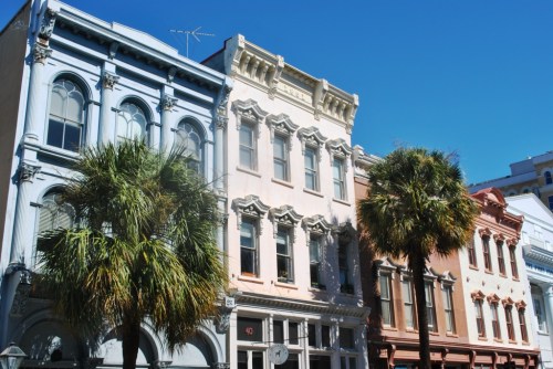 Colorful historic buildings with palm trees under a clear blue sky.