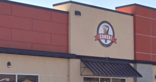 Exterior of a restaurant building featuring a sign that reads "CONED!" with a logo of an ice cream cone.