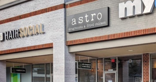Exterior view of a shopping plaza featuring Hair Social and Astro Doughnuts & Fried Chicken storefronts.
