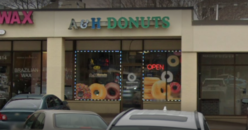 A&H Donuts storefront with colorful donut images and an "OPEN" sign, located in a shopping plaza.
