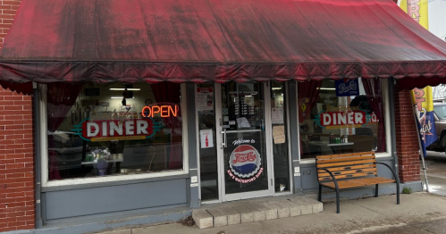 Exterior of Kim’s Waterford Diner in Pennsylvania, with a red awning and a wooden bench.