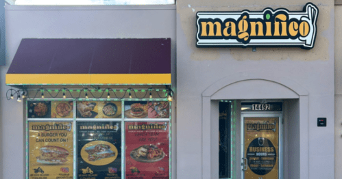 Exterior of a restaurant named "magninico," featuring a menu display and a colorful awning.