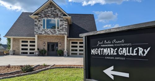 A large, modern house with a stone facade and a sign for "Nightmare Gallery" pointing left in Somerset, Kentucky.