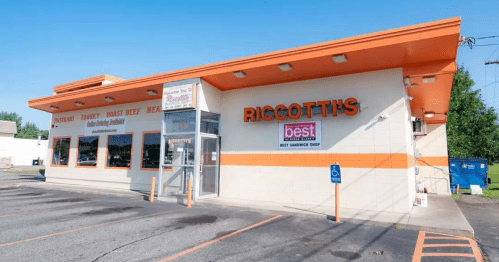 Exterior of Riccotti's, a sandwich shop with orange accents and a sign indicating it's a best sandwich shop.