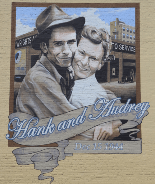 Mural of two men embracing, with the text "Hank and Audrey" and the date "Dec 15 1944" below them.