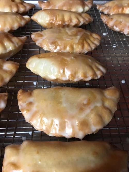Golden-brown pastries arranged on a cooling rack, showcasing a glossy glaze on their surface.