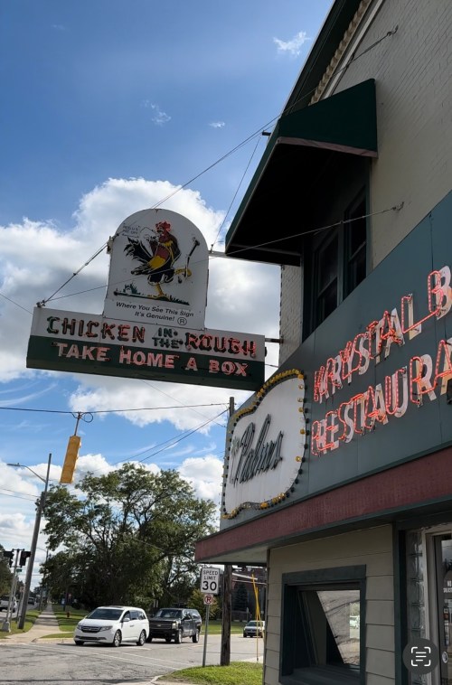 Sign for "Chicken in the Rough" restaurant with a cartoon chicken, featuring "Take Home a Box" and nearby "Krystal Bar."