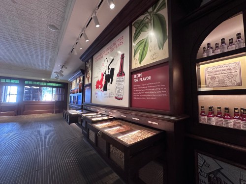 Interior of a museum exhibit featuring displays about flavor recipes and ingredients, with bottles and informative panels.