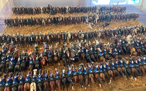 A detailed display of miniature soldiers on horseback arranged in rows, showcasing a historical battle scene.