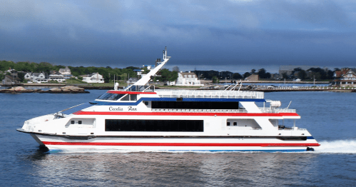 A white and red ferry boat named "Cecilia Ann" cruising through calm waters with a coastal town in the background.
