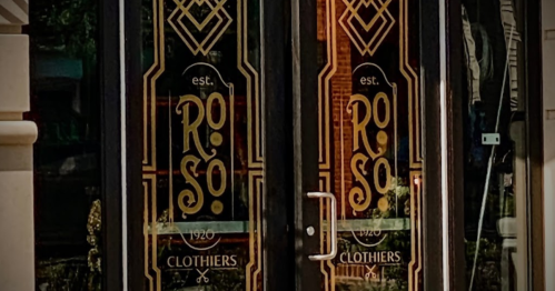 Double doors with ornate designs, featuring the name "RoSo Clothiers" and the establishment year "est. 1920."