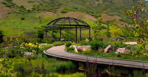 Flowers grow around a boardwalk trail and toward a gazebo at Red Butte Gardens in Salt Lake City, Utah.