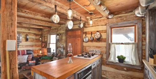 Cozy rustic kitchen with wooden beams, a central island, vintage decor, and a warm, inviting atmosphere.
