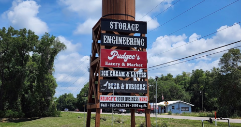 Sign for Pudge's Eatery & Market featuring ice cream, lattes, beer, and burgers, with a storage engineering theme.