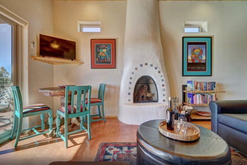 Cozy living space with a fireplace, artwork on the walls, a dining table, and a comfortable seating area.