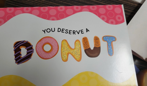 Colorful text reads "You Deserve a DONUT" with various donut illustrations in the letters.