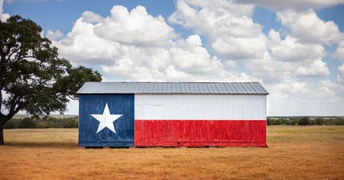 a barn in Texas with the Texas flag painted on the side exterior wall