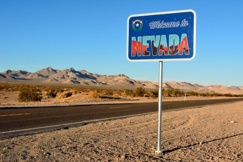 Welcome to Nevada road sign with desert landscape and clear sky in the background