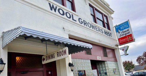 Exterior of Wool Growers Rest with a sign for the dining room and a hotel sign, featuring a vintage style.
