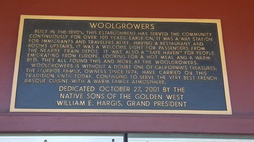 Plaque detailing the history of Woolgrowers, a community establishment serving travelers since the 1890s.