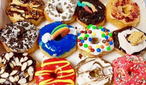 A colorful assortment of decorated donuts with various toppings, including sprinkles, chocolate, and candy.