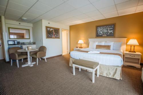 A cozy hotel room featuring a king-sized bed, seating area, and warm lighting.