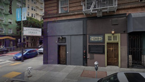 Exterior view of a building featuring the "Anti-Saloon League" sign and two distinct doors on a city street.