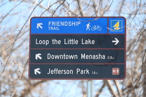 Sign for Friendship Trail with directions to Loop the Little Lake, Downtown Menasha, and Jefferson Park.