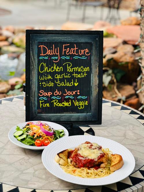 A chalkboard menu displays "Daily Feature: Chicken Parmesan with garlic toast, side salad, and soup of the day."